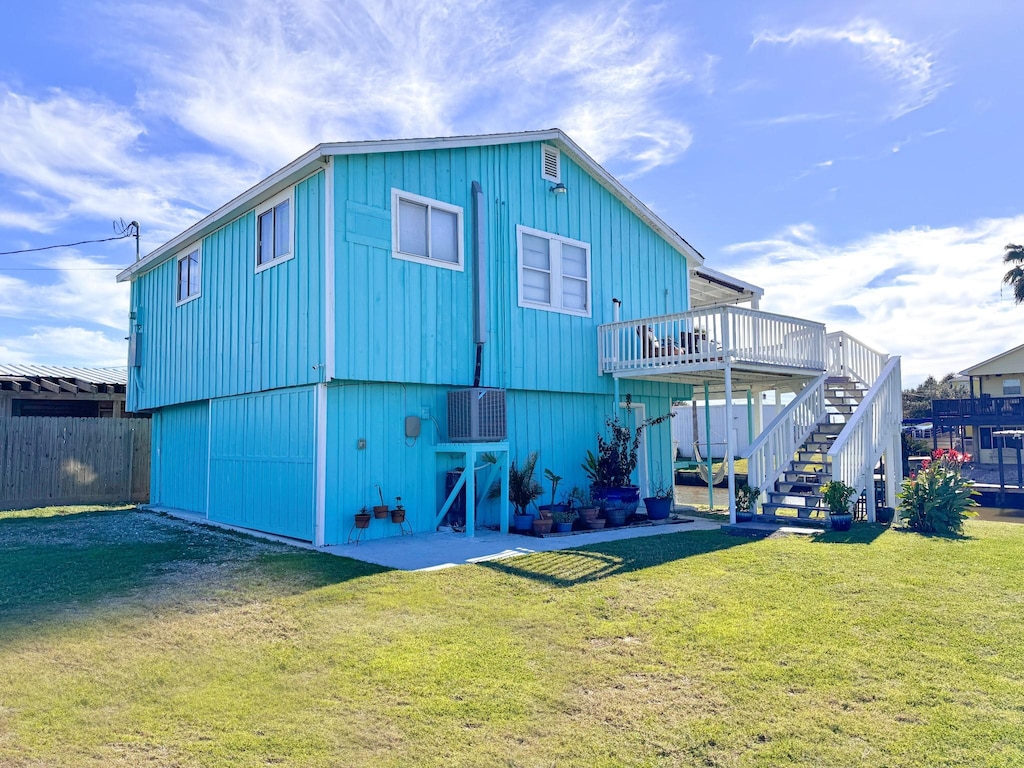 rear view of house featuring a yard and a wooden deck