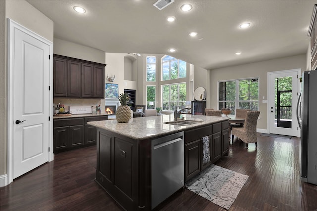 kitchen featuring dark brown cabinetry, a center island with sink, stainless steel appliances, and sink