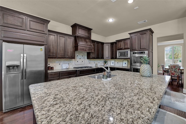 kitchen featuring appliances with stainless steel finishes, an island with sink, and sink