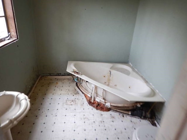 bathroom featuring a tub to relax in and tile patterned flooring