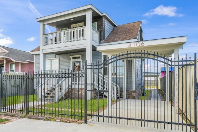 4106 Winnie St, Galveston, TX 77550 - view of front facade featuring a balcony, a gate, a fenced front yard, and roof with shingles