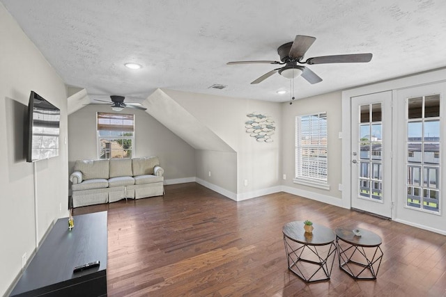 living room featuring dark hardwood / wood-style flooring, a textured ceiling, ceiling fan, and a healthy amount of sunlight