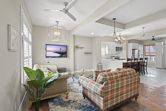 living room with ceiling fan with notable chandelier