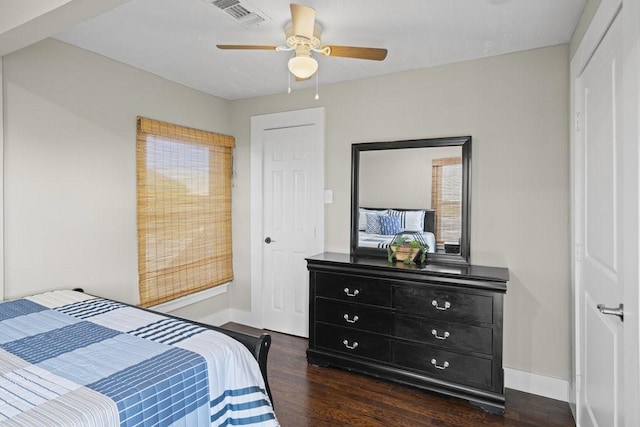 bedroom with multiple windows, ceiling fan, and dark hardwood / wood-style flooring