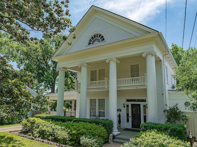 neoclassical home featuring a balcony