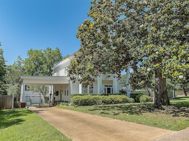 greek revival house featuring a carport and a front yard