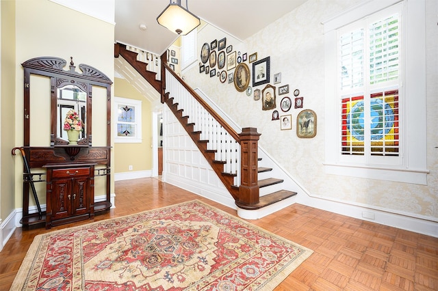 entryway with baseboards, stairway, and wallpapered walls