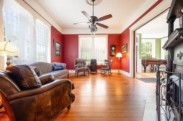 living area featuring baseboards, plenty of natural light, and hardwood / wood-style floors