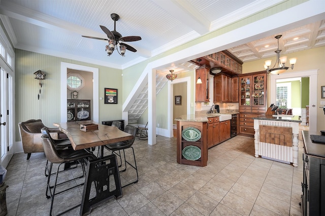 kitchen featuring brown cabinets, ornamental molding, glass insert cabinets, a sink, and beamed ceiling