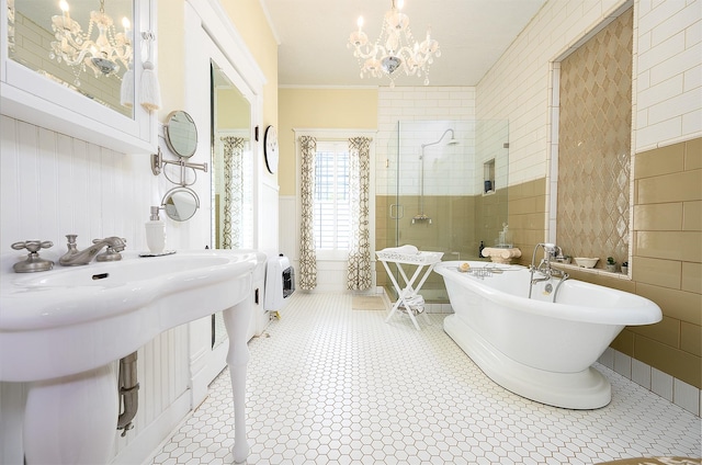 bathroom with tile walls, heating unit, a freestanding bath, a stall shower, and a chandelier