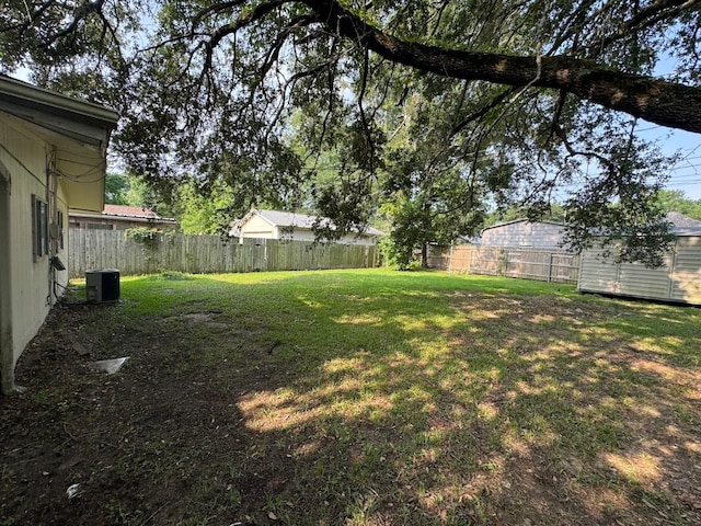 view of yard with central AC and a shed