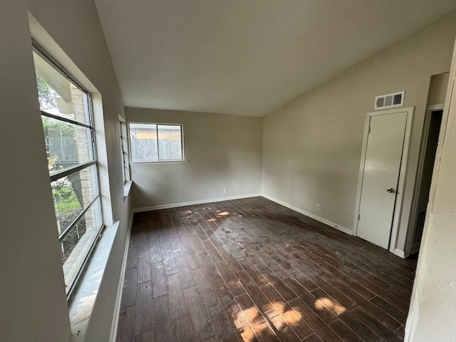 spare room with high vaulted ceiling and dark hardwood / wood-style floors