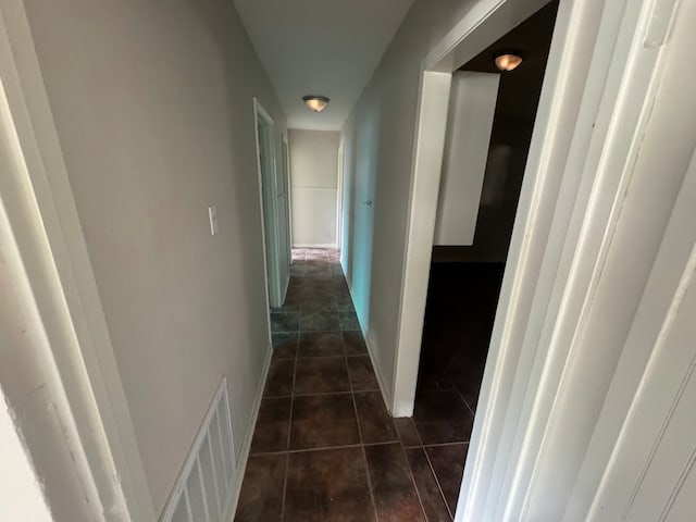 corridor featuring dark tile patterned flooring