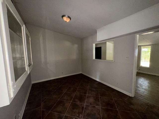 empty room featuring dark tile patterned floors