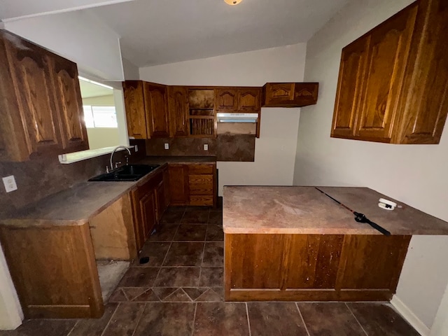 kitchen featuring decorative backsplash, sink, dark tile patterned flooring, and vaulted ceiling