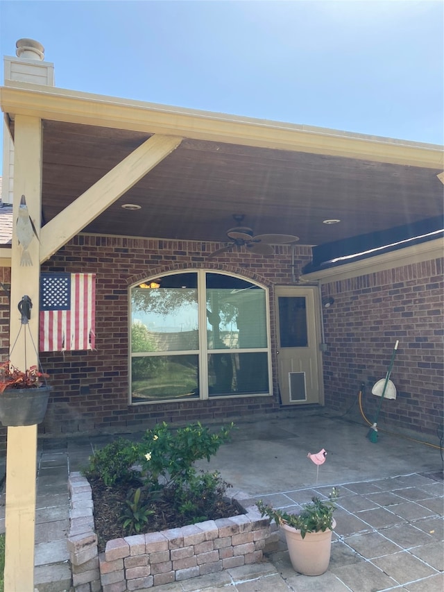 view of exterior entry featuring a patio and ceiling fan