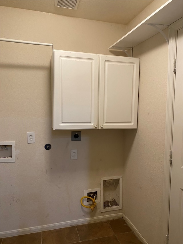 laundry area with hookup for a washing machine, cabinets, hookup for an electric dryer, and dark tile patterned flooring