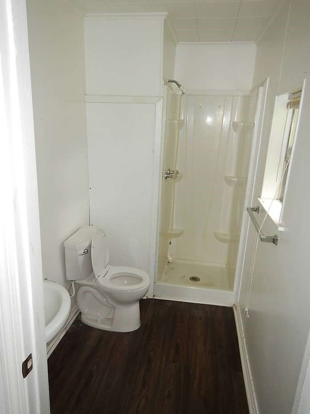 bathroom featuring walk in shower, hardwood / wood-style flooring, and toilet