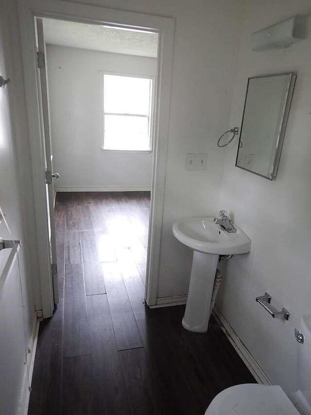 bathroom featuring toilet, hardwood / wood-style floors, and sink