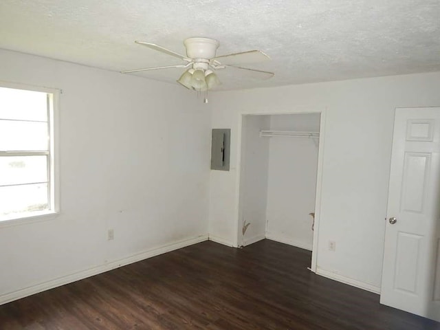 unfurnished bedroom featuring a closet, electric panel, ceiling fan, and dark wood-type flooring