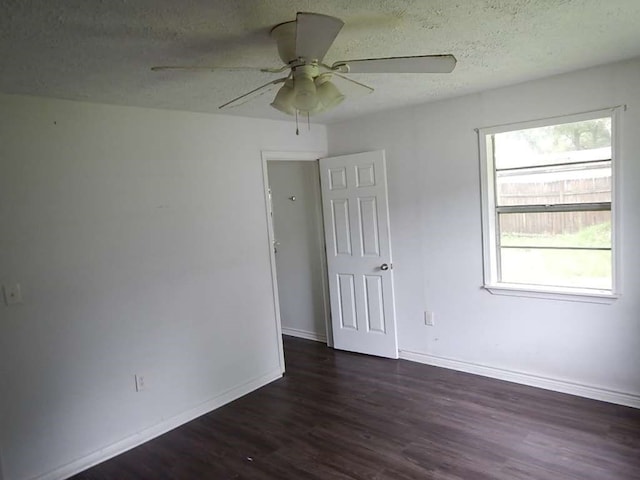 empty room featuring dark hardwood / wood-style floors, ceiling fan, and a textured ceiling