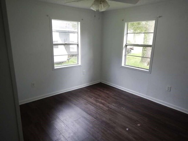 empty room with dark wood-type flooring and ceiling fan