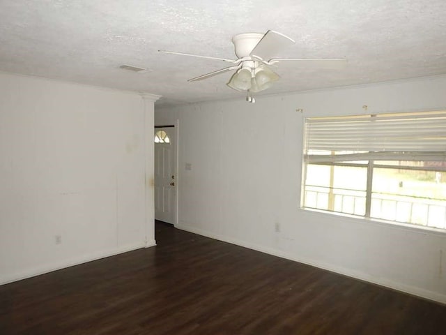 empty room featuring dark hardwood / wood-style flooring, a textured ceiling, and ceiling fan