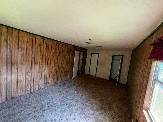 unfurnished bedroom with wooden walls