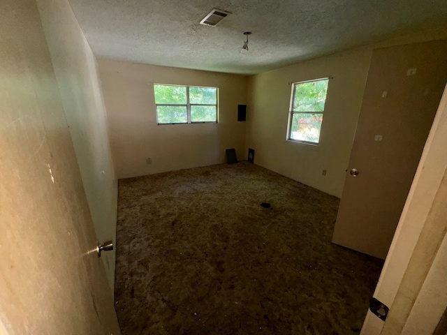 unfurnished room featuring a textured ceiling