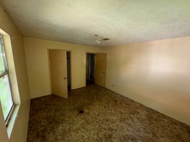 unfurnished bedroom featuring carpet floors and a textured ceiling