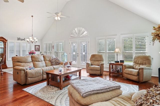 living room featuring ceiling fan with notable chandelier, dark hardwood / wood-style floors, high vaulted ceiling, and a healthy amount of sunlight