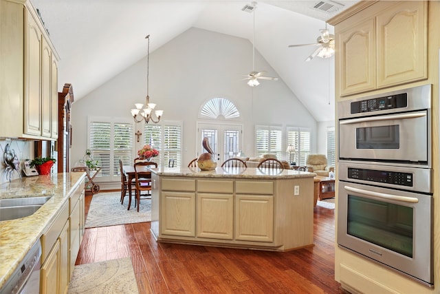 kitchen with high vaulted ceiling, dark hardwood / wood-style floors, decorative light fixtures, and stainless steel appliances