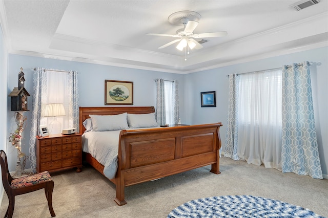 carpeted bedroom featuring a raised ceiling, ornamental molding, and ceiling fan