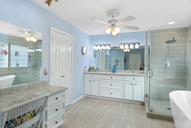 bathroom with ceiling fan, vanity, and plus walk in shower