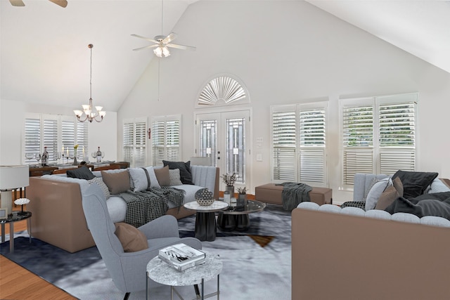 living room featuring ceiling fan with notable chandelier, dark hardwood / wood-style flooring, and high vaulted ceiling