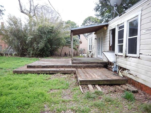 wooden terrace with french doors and a yard