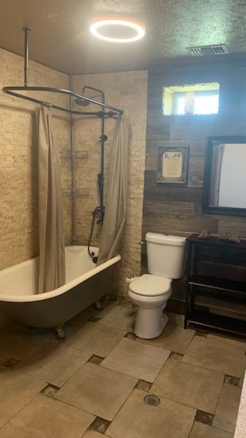 bathroom with shower / bath combo with shower curtain and toilet