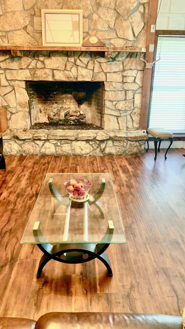 interior space with a stone fireplace and hardwood / wood-style flooring