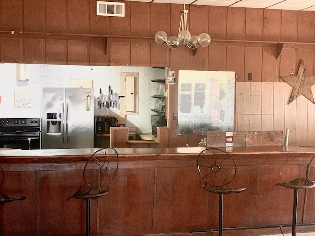 kitchen with black stove and stainless steel fridge