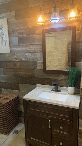 bathroom featuring vanity and wood walls