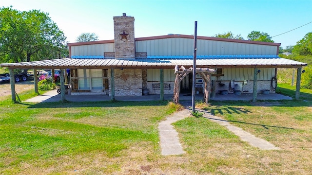 rear view of house with a patio area, a yard, and a carport