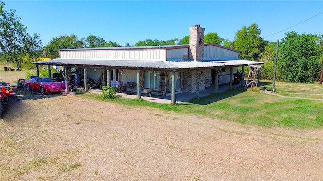 rear view of house featuring a patio area, a yard, and a carport