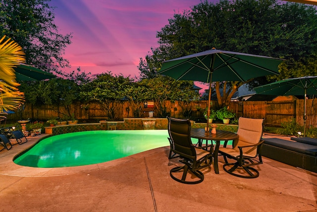 pool at dusk featuring a patio