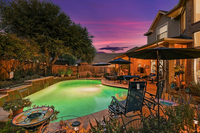 pool at dusk featuring a patio area