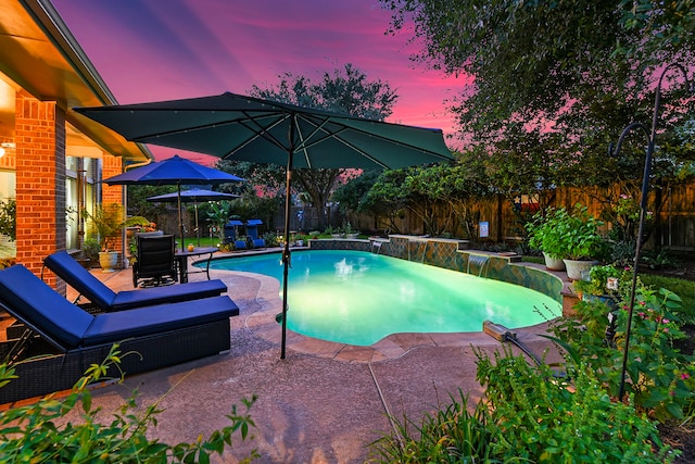 pool at dusk featuring a patio