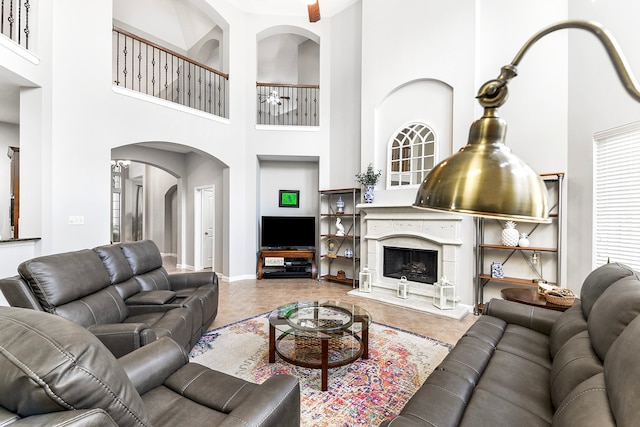 living room featuring a premium fireplace, tile patterned floors, and a towering ceiling