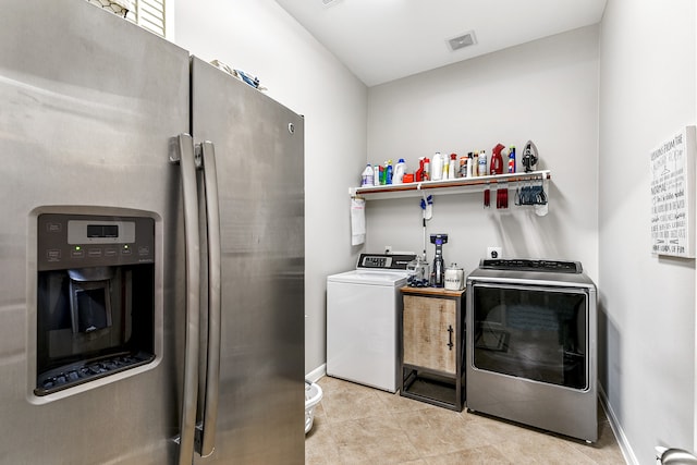 laundry room with washing machine and clothes dryer and light tile patterned floors