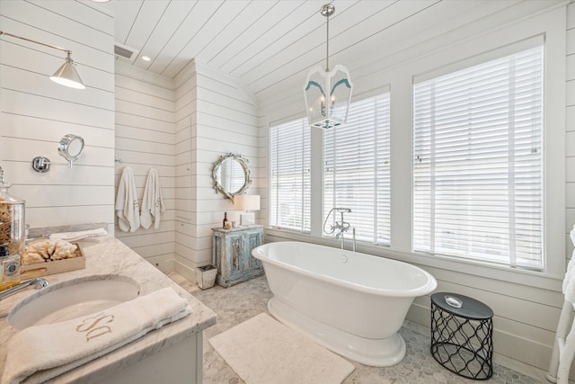 bathroom featuring a washtub, vaulted ceiling, and a wealth of natural light