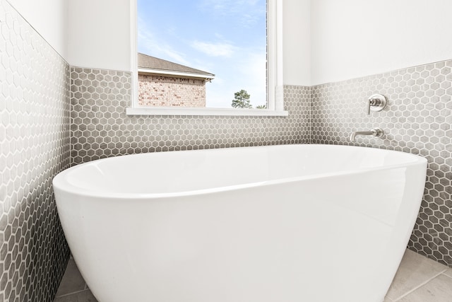 bathroom featuring a bathing tub, tile walls, and tile patterned flooring