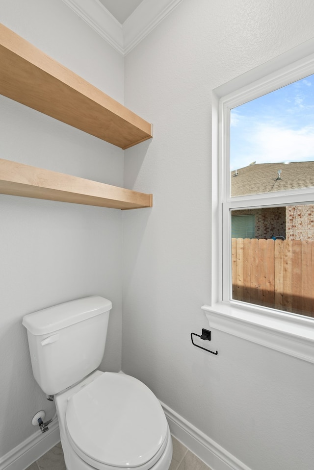 bathroom with crown molding, toilet, and tile patterned floors